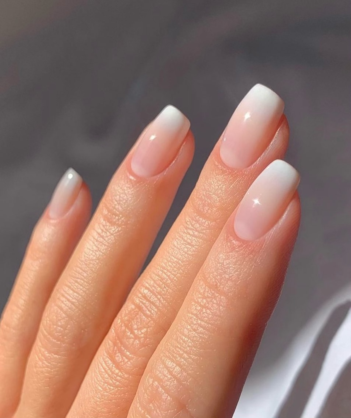 Modny manicure 2025: Różowe paznokcie ombre – manicure z delikatnym gradientem w odcieniach różu i bieli.
