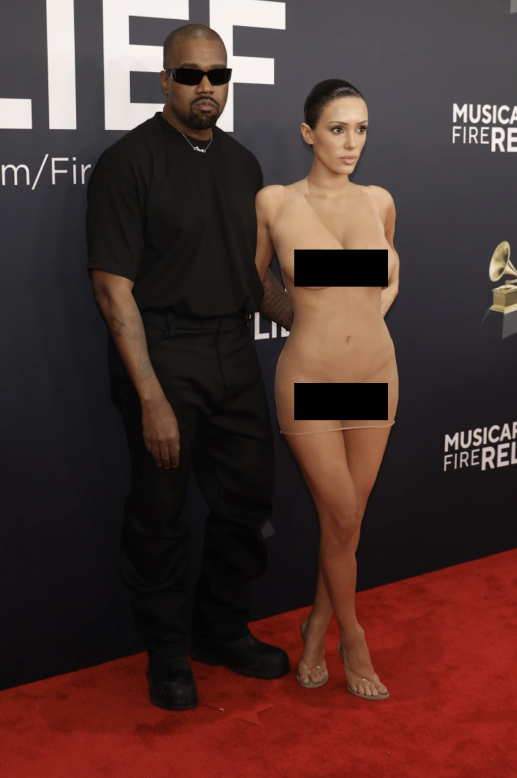 Bianca Censori Grammy 2025: Pozująca z mężem kobieta, w stylizacji odsłaniającej ciało, podczas eleganckiej gali.