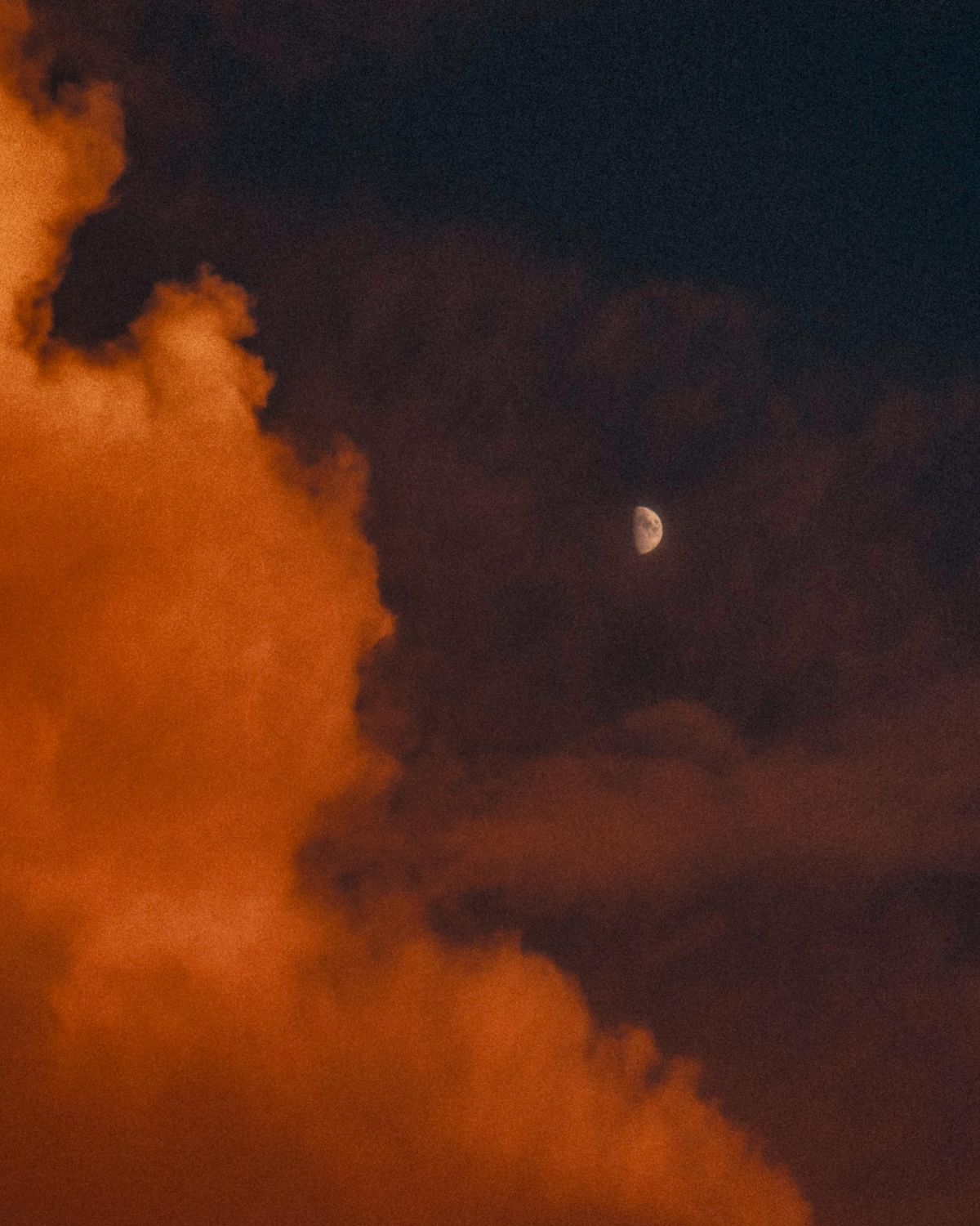 Horoskop tygodniowy 17-23 lutego: zdjęcie przedstawiające zachmurzone niebo z czerwoną łuną, a w oddali księżyc.