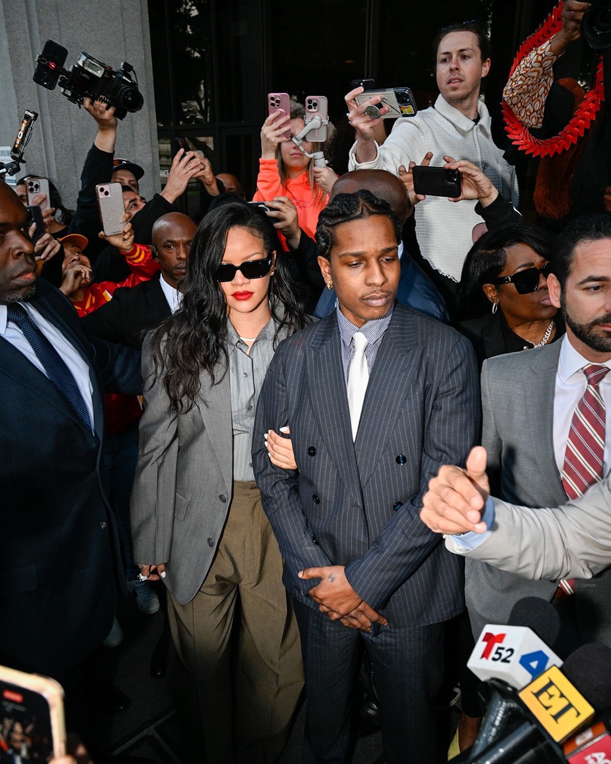 ASAP Rocky uniewinniony – raper i jego partnerka, Rihanna, opuszczają gmach sądu Clara Shortridge Foltz Criminal Justice Center w Los Angeles po ogłoszeniu wyroku uniewinniającego w sprawie dwóch zarzutów o napaść z użyciem półautomatycznej broni palnej. Otoczeni przez tłum fotoreporterów i fanów, para idzie ramię w ramię, ubrana w eleganckie stylizacje. Wokół nich widać ochroniarzy, dziennikarzy i osoby nagrywające moment na telefonach.