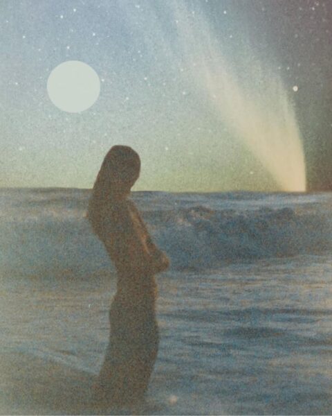 Ilustracja przedstawiająca horoskop na równonoc 2025. Widać na niej kobietę stojącą na brzegu morza, które jest wzburzone i widać fale. W tle, na niebie widać także księżyc oraz zorzę