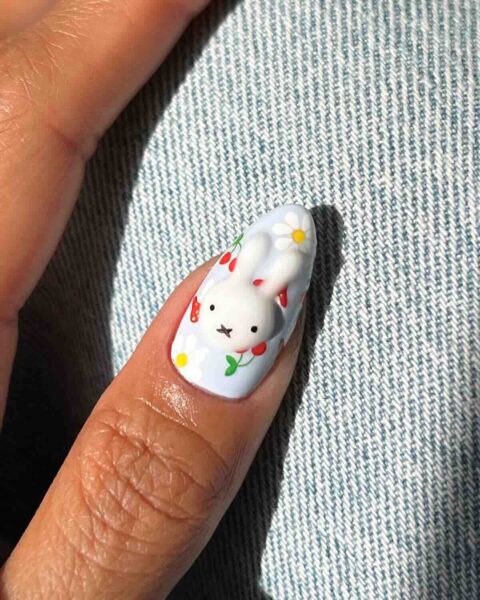 Uroczy króliczek 3D na paznokciu z pastelowym tłem i kwiatowymi detalami – trójwymiarowy manicure z białym króliczkiem, stokrotkami i truskawkami w stylu kawaii to idealna propozycja na Wielkanoc 2025 dla fanek bajkowych akcentów i słodkich zdobień.