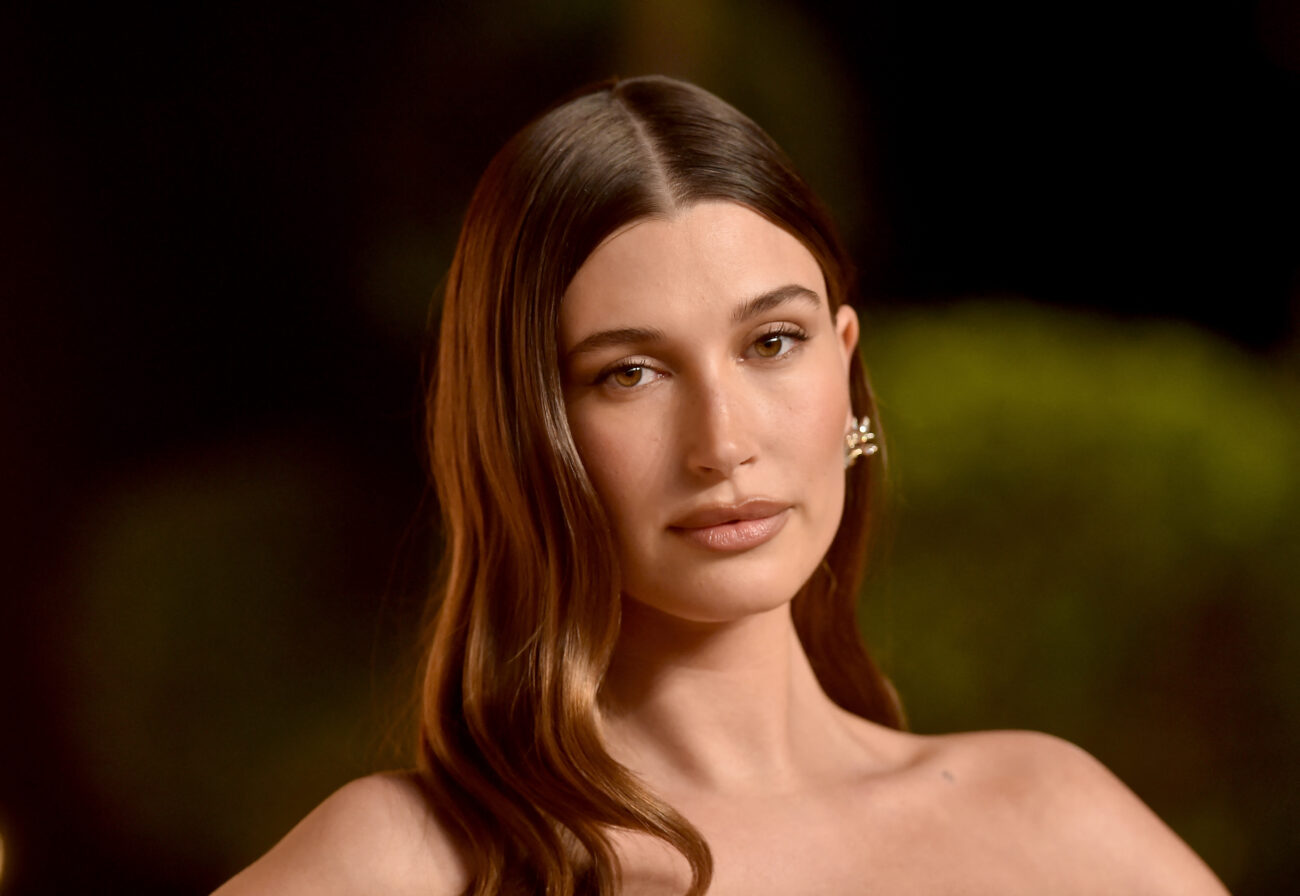 Zbliżenie na Hailey Bieber podczas uroczystej gali w trakcie trwania czerwonego dywanu.