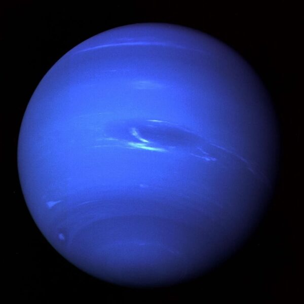 Zdjęcie przedstawia planetę Neptun na tle czarnej przestrzeni kosmicznej. Planeta jest okrągła i wypełnia większą część kadru. Jej kolor jest intensywnie niebieski, z subtelnymi jaśniejszymi i ciemniejszymi pasmami oraz wirami, sugerującymi aktywność atmosferyczną. W centrum planety widoczne są jaśniejsze, wydłużone struktury, przypominające chmury. Cała planeta jest równomiernie oświetlona, a jej kulisty kształt jest wyraźnie widoczny na tle ciemnego kosmosu.