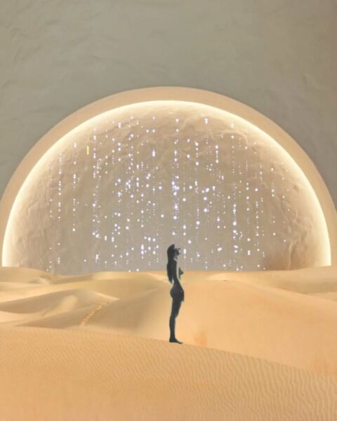 Ilustracja w ezoterycznym stylu. Widać pustynię, na której stoi kobieta. W tle widać niebo, a na nim rozpościera się wielka planeta z lśniącymi refleksami.