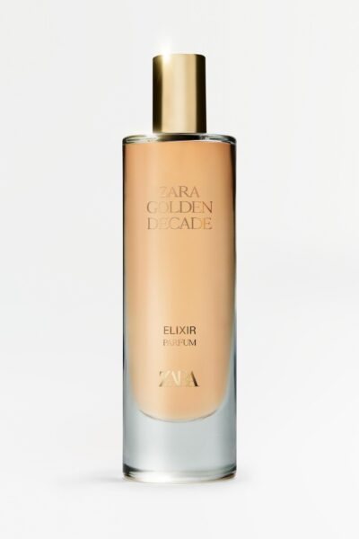 Butelka perfum Zara Golden Decade Elixir w eleganckim, wysokim flakonie o złocistej barwie i złotym korku. Minimalistyczny design z subtelnym logotypem marki oraz nazwą zapachu wpisaną delikatną czcionką. Tło jest białe, co podkreśla luksusowy charakter produktu.