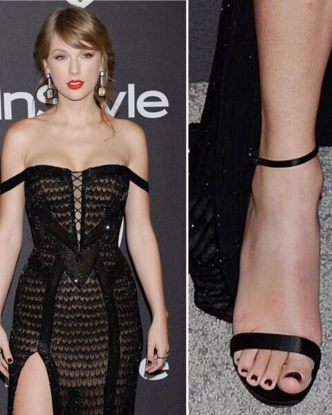 Zdjęcie piosenkarki Taylor Swift. Pozuje na ściance ubrana w dopasowaną, czarną sukienkę ażurową z dekoltem karmen oraz rozcięciem na nodze. Ma ciemnoblond włosy spięte w kok. W uszach wiszące kolczyki. Na nogach ma czarne sandałki i czarny pedicure.