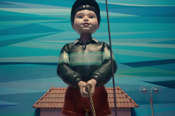 Gigantyczna lalka z gry „Zielone światło, czerwone światło” z „Squid Game” patrzy nieruchomo przed siebie w trakcie rozgrywki. Jej przerażająco spokojna twarz kontrastuje z grozą, jaką sieje podczas gry eliminacyjnej.