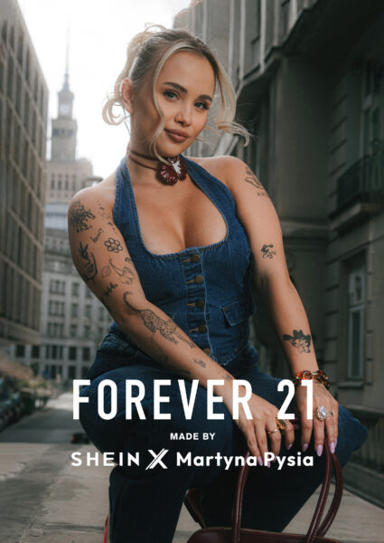 Stylizacje Martyny Zabierajskiej: Martyna Pysia w kampanijnym ujęciu promującym kolekcję Forever 21 x SHEIN. Ubrana w dżinsowy top na ramiączkach, pozuje na tle Pałacu Kultury i Nauki. U dołu widoczne logo Forever 21 oraz napis „MADE BY SHEIN x Martyna Pysia”. Zdjęcie symbolizuje połączenie światowej marki z osobistym stylem influencerki.
