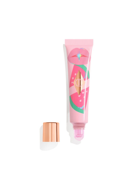 Błyszczyk do ust Unreal Lips Healthy Glow Nectar Oil marki Charlotte Tilbury w różowym opakowaniu z grafiką przedstawiającą usta i arbuz. Otwarte opakowanie z widocznym aplikatorem w odcieniu różowego nektaru.
