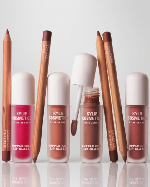 Zdjęcie reklamowe prezentujące konturówki i błyszczyki do ust Kylie Cosmetics. Stoją na szklanym blacie.