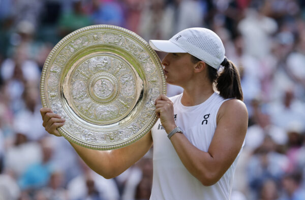 Polska tenisistka Iga Świątek całuje srebrną paterę po swoim pierwszym zwycięstwie w Wimbledonie. Detaliczne ujęcie z bliska podkreśla emocjonalny wymiar sukcesu i sportową dumę mistrzyni.