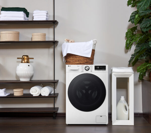 Pralka LG F4W10722W w jasnym, nowoczesnym wnętrzu pralni z elementami dekoracyjnymi i roślinnością.