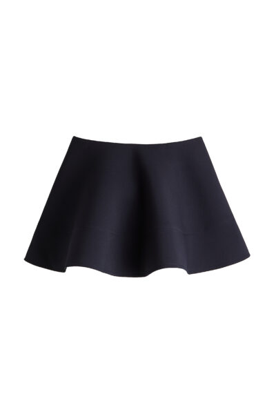 Trendy H&M jesień 2025: Prosta, ale efektowna krótka spódnica o rozkloszowanym fasonie. Wykonana z grubszego materiału, trzymającego kształt. Głęboki granatowy kolor dodaje elegancji, idealna do łączenia z różnymi fakturami górnej części garderoby.