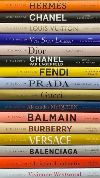 Fendi. Historia kultowego domu mody: Stos kolorowych książek z serii Little Book of Fashion, prezentujących historię najbardziej ikonicznych domów mody: Hermès, Chanel, Louis Vuitton, Yves Saint Laurent, Dior, Fendi, Prada, Gucci, Alexander McQueen, Balmain, Burberry, Versace, Balenciaga, Christian Louboutin oraz Vivienne Westwood. Widoczna różnorodność barwnych grzbietów symbolizuje indywidualny charakter każdej marki.
