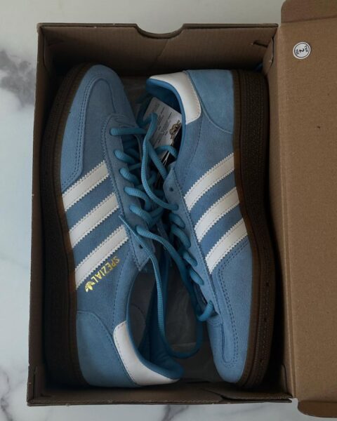 Zdjęcie pudełka zawierające oryginalne buty adidas Samba w kolorze niebieskim.