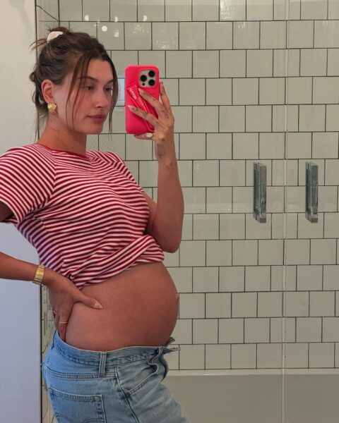 Hailey Bieber drugie dziecko: Ciężarna kobieta w zaawansowanym stadium robiąca zdjęcie przed lustrem.