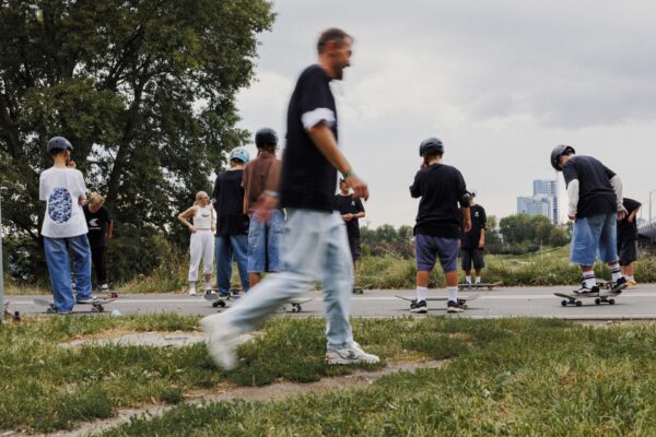 Grupa uczestników warsztatów longboardowych prowadzonych w Poznaniu podczas premiery marki Cariuma w Polsce. Młodzi skaterzy uczą się jazdy w atmosferze streetwearu i wspólnoty.