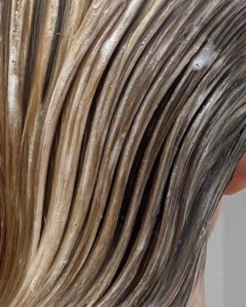 Zdjęcie z mocnym zbliżeniem na blond włosy pokryte odżywką do włosów.