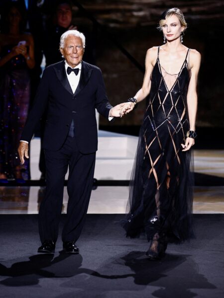 Pokaz mody Armaniego w Wiecznym Mieście – projektant w smokingu prowadzi za rękę modelkę w przeźroczystej, geometrycznej sukni haute couture, otrzymując owacje na stojąco od publiczności.