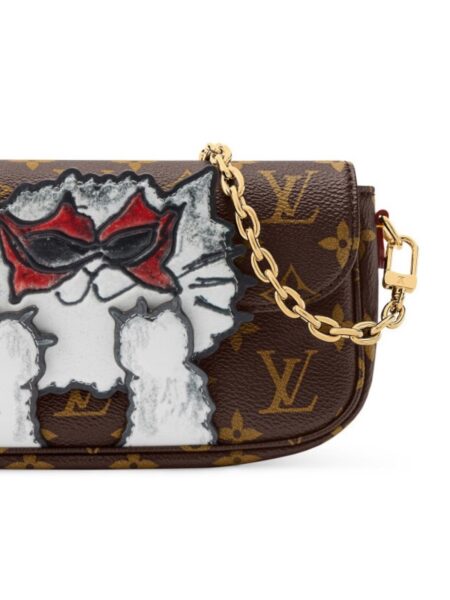 Torba Louis Vuitton z grafiką kota – brązowa torebka na ramię Louis Vuitton w klasycznym monogramie z zabawnym nadrukiem białego kota w czerwono-czarnych okularach przeciwsłonecznych; złoty łańcuszek i pasek z jasnej skóry kontrastują z ciemnym płótnem, tworząc efekt nowoczesnego, artystycznego dodatku.