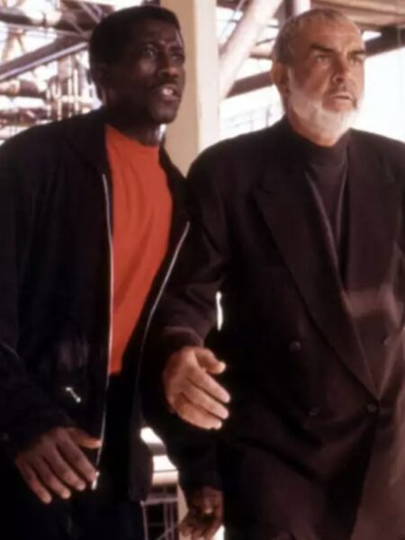 Sean Connery i Wesley Snipes w filmie „Rising Sun” (1993) – Connery w ciemnym, doskonale skrojonym garniturze Armaniego, zestawionym z golfem, nadaje postaci powagę i elegancję. Obok niego Snipes w czerwonej koszulce i casualowej kurtce kontrastuje stylem, co odzwierciedla różnice charakterów bohaterów.