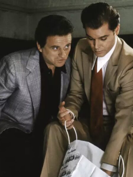 Ray Liotta i Joe Pesci w filmie „Chłopcy z ferajny” (1990) – scena ukazuje ich w starannie dobranych garniturach Armaniego. Liotta w jasnym, beżowym garniturze z czerwonym krawatem, a Pesci w kraciastym zestawie – ubrania stają się wizualnym symbolem statusu, bogactwa i aspiracji mafijnego półświatka.
