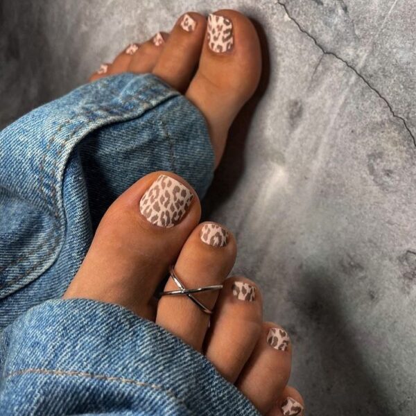 Beżowy pedicure z pełnym wzorem panterki na wszystkich paznokciach – mocny akcent w klimacie lat 2000., idealny dla osób, które chcą połączyć modę Y2K z jesiennym lookiem.