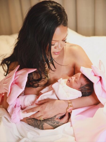 Rihanna urodziła 3 dziecko: Rihanna w intymnym, czułym kadrze, trzymająca w ramionach nowonarodzone dziecko. Piosenkarka ubrana jest w różową stylizację z dużymi kokardami na rękawach, a na jej nadgarstku połyskuje złoty zegarek. Dziecko ubrane jest w różowe ubranko i spokojnie śpi, wtulone w matkę.