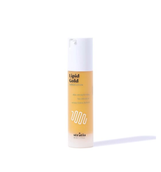 Stratia Lipid Gold Barrier Lotion – smukła buteleczka typu airless w kolorze złotym, zakończona białą pompką; emulsja wzmacniająca barierę hydrolipidową, inspirowana bio-identycznymi lipidami.