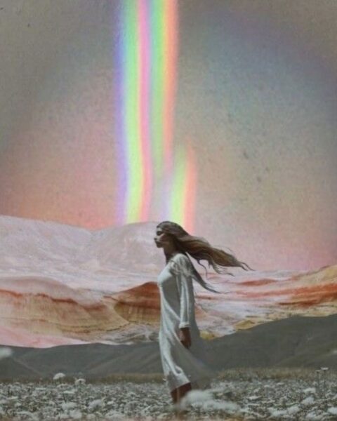Eteryczna kompozycja w pastelowych, ciepłych barwach, utrzymana w estetyce vintage lub lo-fi. Kobieta z długimi, rozwianymi włosami stoi w białej, długiej sukience na pokrytej kwiatami łące, na tle malowniczych, górzystych wzgórz w odcieniach różu i ochry. Ponad nią, na niebie, dominuje jaskrawa, pionowa kolumna tęczowego światła. Całość symbolizuje duchowe przebudzenie, połączenie z naturą i wewnętrzną siłą.