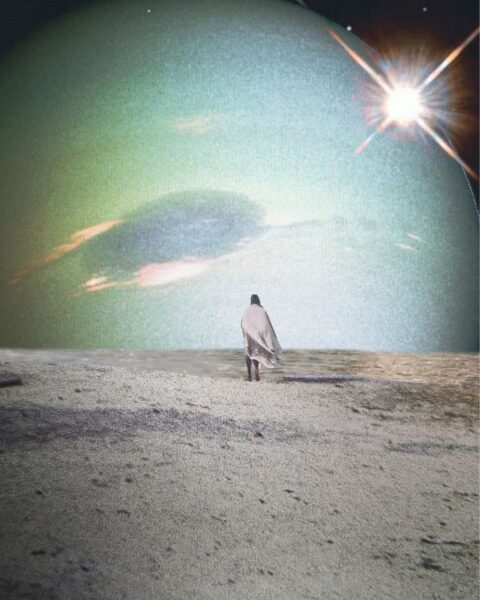 Postać w jasnym, powiewającym okryciu lub pelerynie stoi na piaszczystej plaży lub wydmie, patrząc na ogromną planetę lub księżyc dominujący na niebie. Na pierwszym planie widać ziarnisty piasek, a na horyzoncie lśni jasna gwiazda lub słońce.