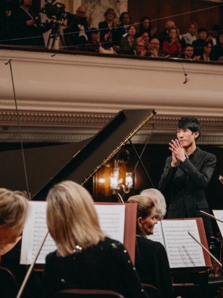 Eric Lu wstaje od fortepianu, składając dłonie w geście wdzięczności wobec orkiestry i publiczności. Widownia wypełnia Filharmonię Narodową, a za nim rozbrzmiewają oklaski po wykonaniu koncertu Chopina.