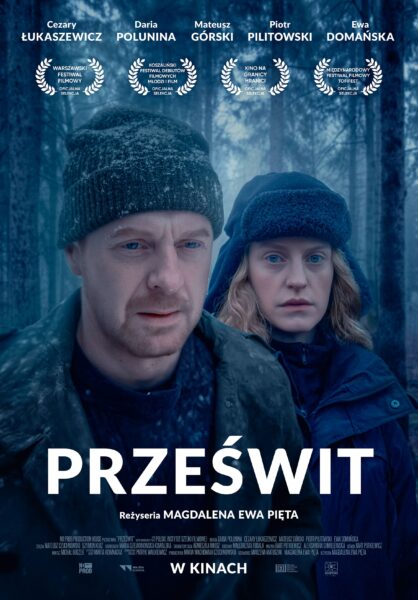 Oficjalny plakat filmu „Prześwit” w reżyserii Magdaleny Ewy Pięty. Na pierwszym planie mężczyzna i kobieta w zimowych ubraniach stoją w zasypanym śniegiem lesie, z wyrazem napięcia i zamyślenia na twarzach. U góry plakatu widnieją nazwiska aktorów: Cezary Łukaszewicz, Daria Polunina, Mateusz Górski, Piotr Pilitowski i Ewa Domańska oraz laurele festiwalowych selekcji. Na dole duży tytuł filmu „Prześwit” i informacja „w kinach”.