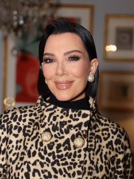 Kris Jenner przed i po. Zdjęcie z bliska przedstawia Kris Jenner uśmiechającą się subtelnie, z włosami zaczesanymi do tyłu w elegancki sposób. Ma na sobie płaszcz lub marynarkę w panterkę (czarno-beżową) z dużymi, złotymi, wysadzanymi kryształkami guzikami. Pod spodem widać czarny golf. Nosi duże, owalne kolczyki z kryształami. Tło to wnętrze z ramami na ścianie.