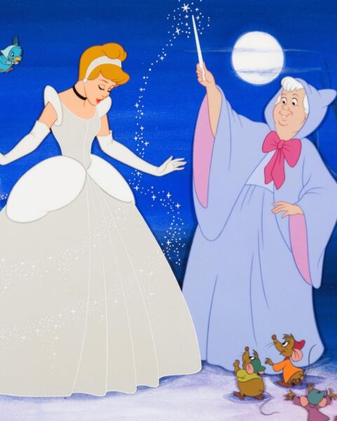 Klasyczna ilustracja z Kopciuszka (Disney). Kopciuszek w lśniącej białej sukni balowej, długich rękawiczkach i czarnym naszyjniku, stoi z pochyloną głową. Obok niej Wróżka Chrzestna w niebieskiej szacie z kapturem i różową kokardą, trzymająca magiczną różdżkę i rzucająca pył gwiezdny na Kopciuszka. W dolnej części obrazu widoczne są myszy Gus i Jaq. Tło to ciemnoniebieska noc z dużą, jasną pełnią księżyca i małym niebieskim ptakiem w lewym górnym rogu.