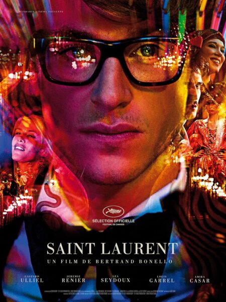 Plakat filmowy do filmu "Saint Laurent". Przedstawia on z bliska twarz mężczyzny (Gaspard Ulliel jako Yves Saint Laurent) w okularach w czarnych oprawkach. Obraz jest bardzo nasycony, utrzymany w psychodelicznych kolorach (purpura, czerwień, żółć), z jaskrawymi światłami odbijającymi się w szkłach. W tle i po bokach portretu widać zmultiplikowane, rozmyte wizerunki innych postaci. Na dole widnieje tytuł "SAINT LAURENT".