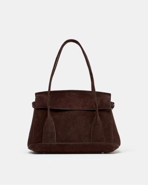 Ciemnobrązowa torebka na ramię wykonana z zamszu, o prostym, klasycznym fasonie. Torba z krótkimi, szerokimi rączkami, idealna do jesiennych i zimowych stylizacji, klasyka mody damskiej.