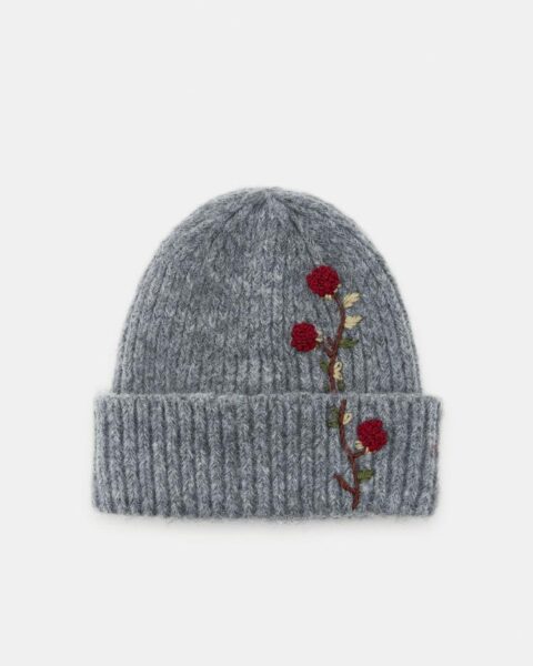 Szara, wełniana czapka beanie z wywiniętym brzegiem i ozdobnym haftem czerwonych róż. Ciepłe i stylowe nakrycie głowy na zimę, akcesoria z modnym detalem dla kobiet z klasą.