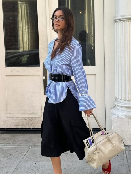 Koszulowa stylizacja z wyraźnie zaznaczoną talią pokazuje, jak trendy luksusowe w 2026 roku przywracają znaczenie sylwetce i proporcjom. Klasyczna koszula w paski, szeroki pasek i prosta spódnica tworzą look, w którym elegancja wynika z konstrukcji i detalu, a nie z nadmiaru ozdób.