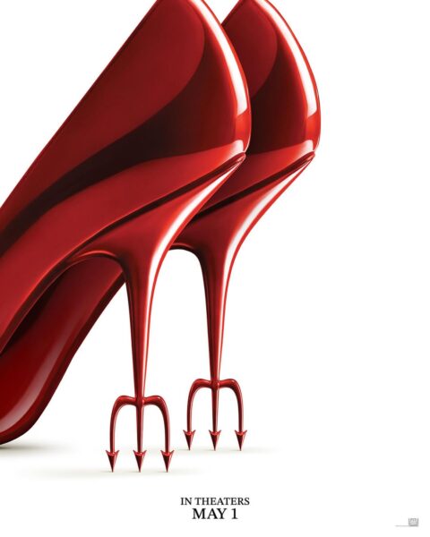Grafika ukazuje parę lśniących, czerwonych szpilek na białym tle, których obcasy zakończone są metalicznymi, trójzębnymi kolcami. Ten intrygujący i nieco niepokojący motyw, w połączeniu z informacją o premierze "IN THEATERS MAY 1", sugeruje komedię satyryczną lub thriller o modzie i zemście. Intensywna czerwień i ostre zakończenia tworzą wizualny symbol zła lub kobiecej siły. Plakat filmu diabeł ubiera się u prady 2.