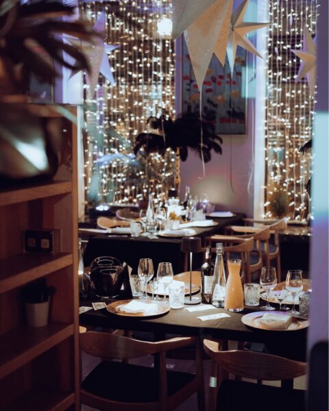 Eleganckie wnętrze restauracji z nastrojowym oświetleniem, świątecznymi dekoracjami i starannie nakrytymi stolikami gotowymi na wieczornych gości. To właśnie taki klimat oferują restauracje otwarte w drugi dzień świąt w Warszawie, wybierane na spokojną kolację poza domem. Idealna propozycja dla osób, które chcą 26 grudnia spędzić w bardziej restauracyjnej niż domowej atmosferze.