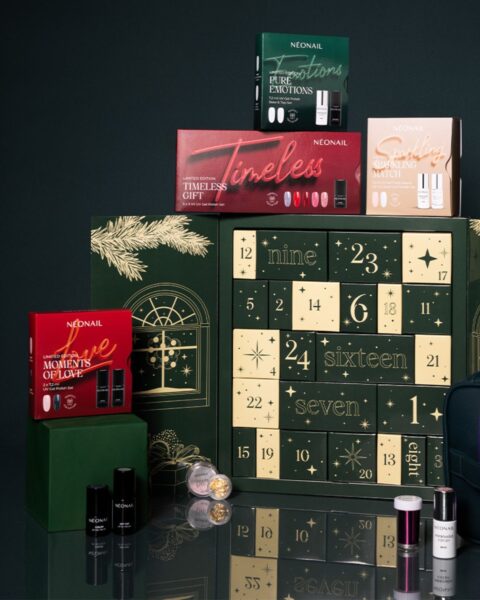 Zdjęcie prezentuje piramidę produktów NEONAIL w świątecznej aranżacji. Centralnym elementem jest duży, zielony kalendarz adwentowy z numerowanymi drzwiczkami. Wokół niego ułożone są inne świąteczne zestawy w kartonikach, m.in. zielony "Pure Emotions", czerwony "Timeless Gift", beżowy "Sparkling Match" i czerwony "Love" (opakowanie 5x3 ml UV Gel Polish Set). Na dole widać pojedyncze buteleczki lakierów hybrydowych, małe pudełeczka z płatkami oraz pędzelek. Tło jest ciemnozielone.