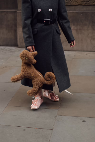 Satynowe sneakersy w pudrowo-różowym odcieniu zestawione z długim, ciemnym płaszczem tworzą elegancki kontrast stylów. Delikatny połysk satyny podkreśla luksusowy charakter obuwia. To przykład, jak najmodniejsze buty na 2026 rok łączą sportową formę z wyrafinowaną estetyką.