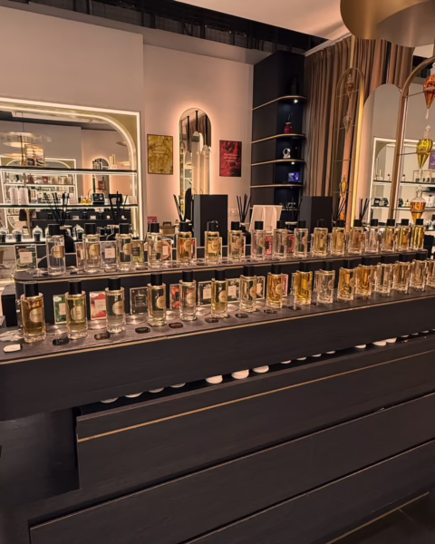 Elegancki butik z ekskluzywną ekspozycją flakonów perfum na czarnym, minimalistycznym stole. Wnętrze łączy styl i nowoczesność – dokładnie tak, jak najlepsze perfumy 2026, które przyciągają nie tylko zapachem, ale i formą.