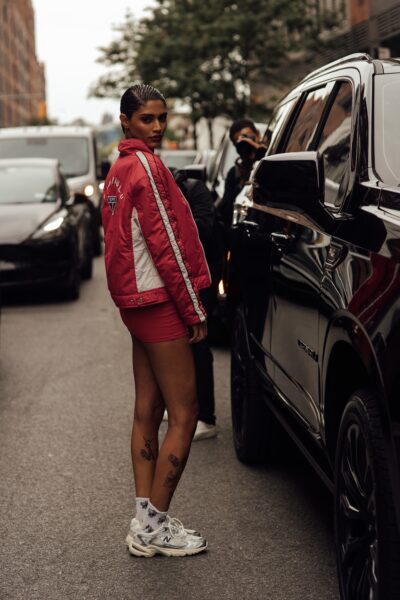 Techniczne dad sneakers w jasnej kolorystyce zestawione z krótką spódnicą i sportową kurtką podkreślają miejski, dynamiczny styl. Modne sneakersy na wiosnę 2026 w wydaniu biegowym wychodzą z siłowni prosto na ulice.