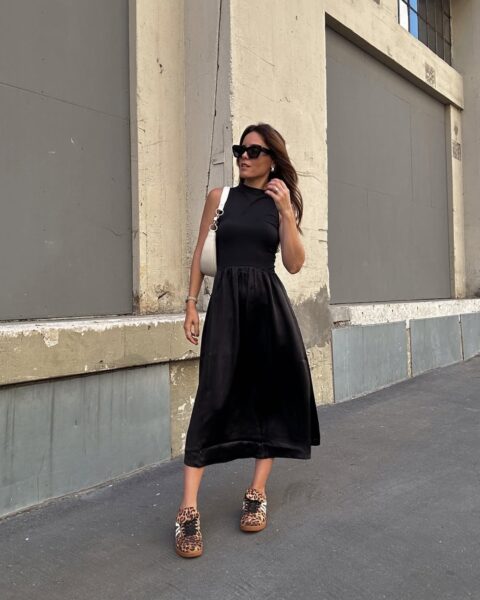 Kobieta w czarnej, minimalistycznej sukience midi zestawiła stylizację z sneakersami w panterkę, które przyciągają wzrok i nadają całości modowego charakteru. Modne sneakersy na wiosnę 2026 w animal print to mocny akcent, który ożywia klasyczny look i świetnie sprawdza się w miejskich stylizacjach.